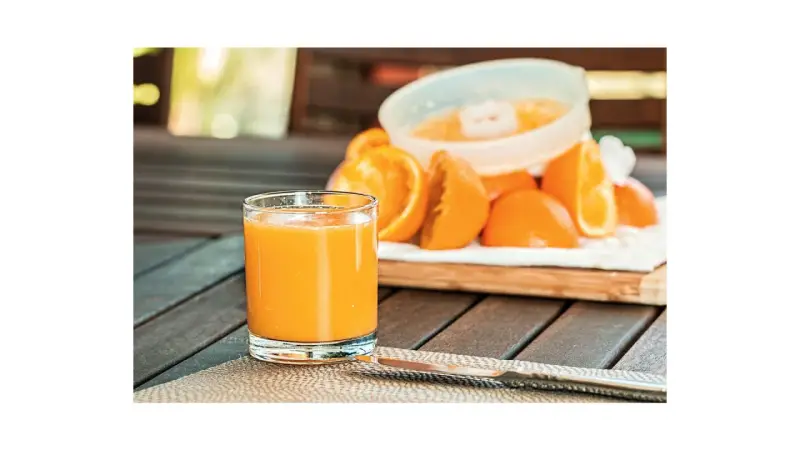 Succo d'arancia fresco, un bicchiere pieno di cibi frutta con vitamina D, pronto per essere gustato.